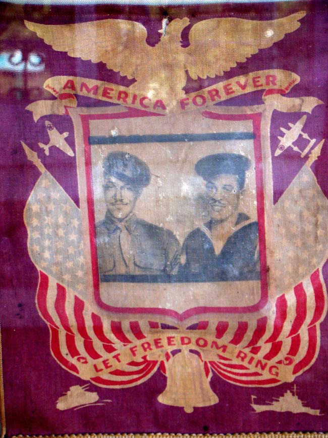 A World War II linen banner with photographic images of two African American brothers, one a sailor, the other a soldier. Circa 1941-1945.